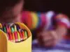 A child coloring with crayons.